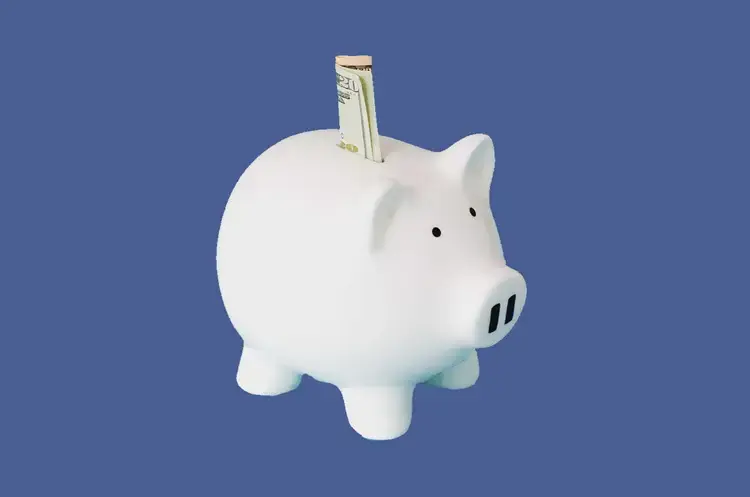 Piggy bank with a banknote, illustrating partner referral rewards.